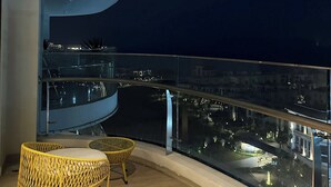 A balcony with a curved railing, a round wicker chair, and a second chair with a cushion. - CMH Homestay A side - 5star standard (Halong City)