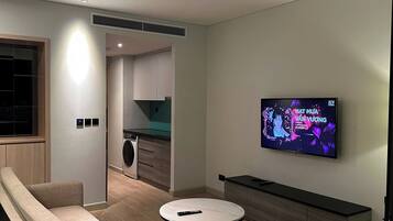 Ein modernes Wohnzimmer mit einer Couch, einem Couchtisch und einem an der Wand befestigten Fernseher.