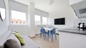 Een modern appartement met een zithoek, eethoek en kitchenette.