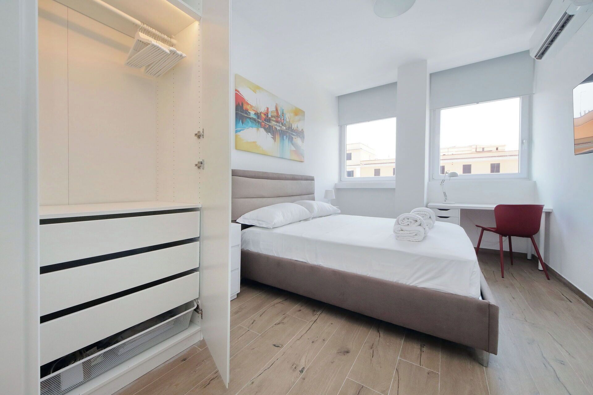 Un dormitorio moderno con una cama, un escritorio y una silla.