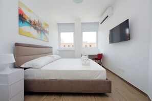 A hotel room with a bed, a desk, a chair, a TV, and a painting on the wall. - Apartment in Rome with 1 bedrooms sleeps 4 (Rome)