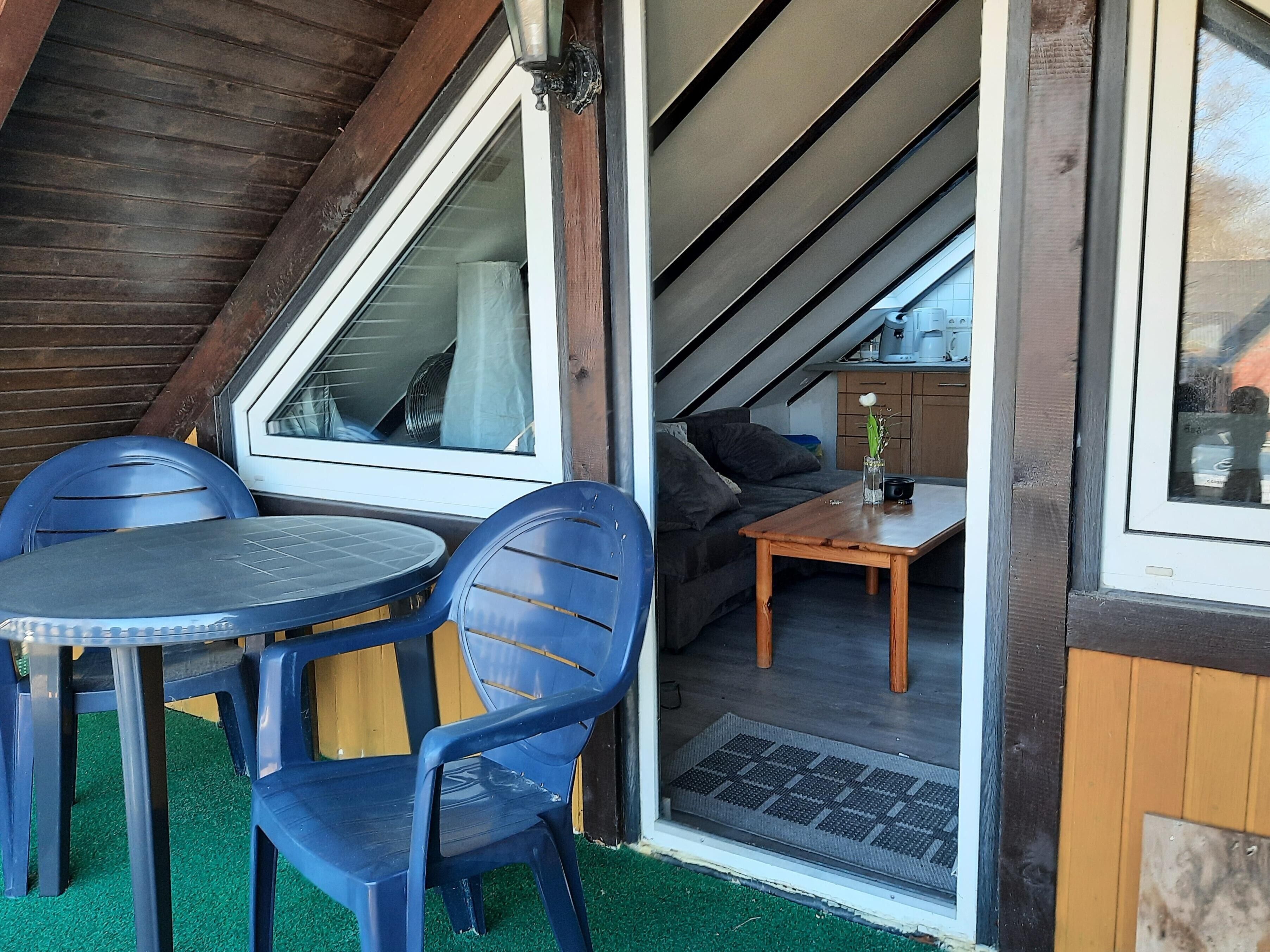 Une petite pièce agréable, avec un plafond en bois, une table entourée de chaises et un canapé.