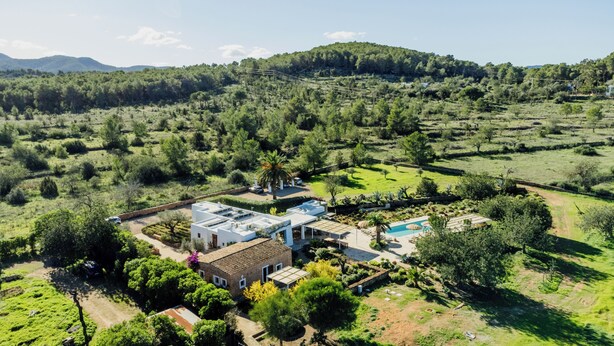 A residential property with a swimming pool, a garden, and a view of a forested area.