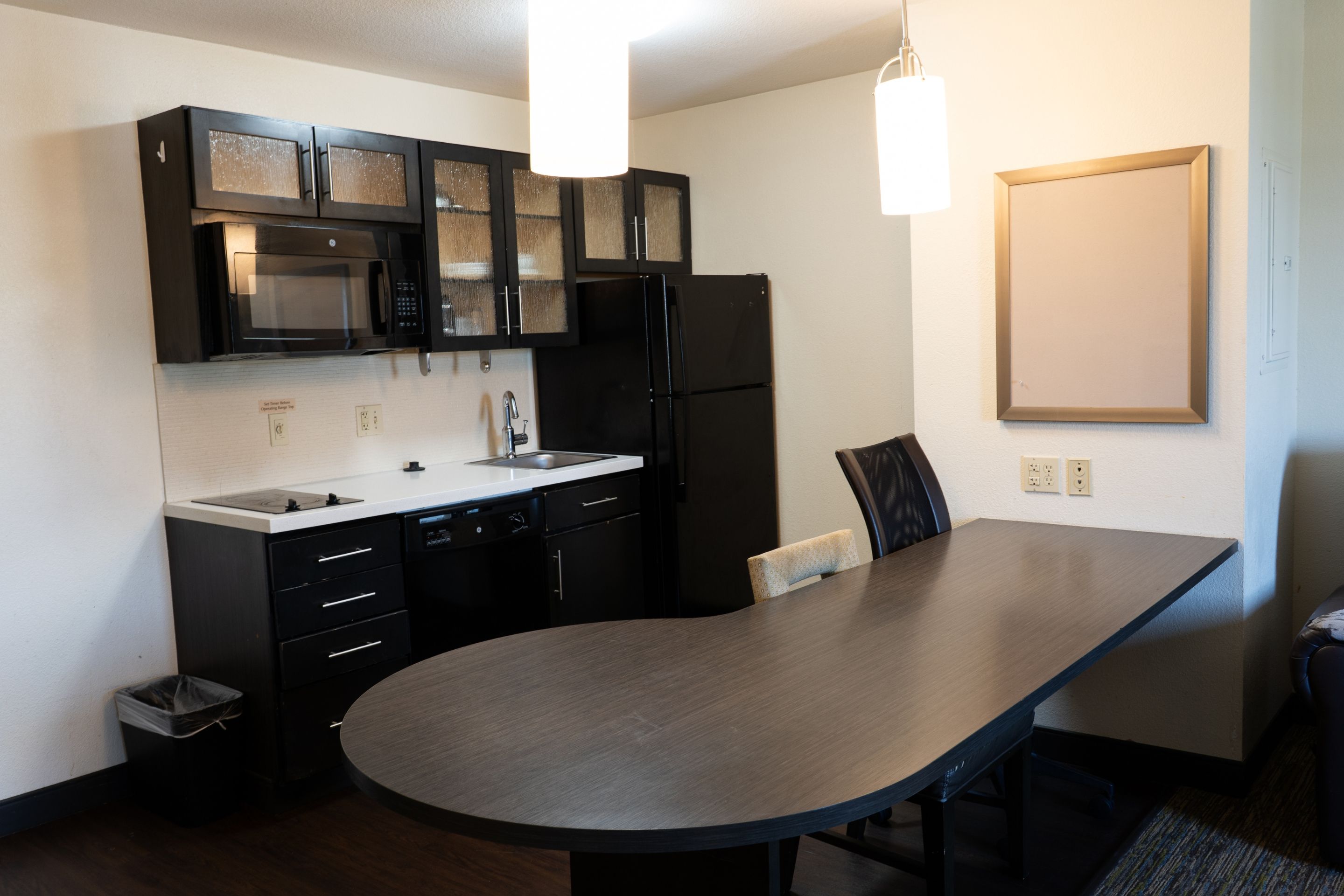 Una cocina moderna con microondas integrado, refrigerador y una amplia mesa de comedor.