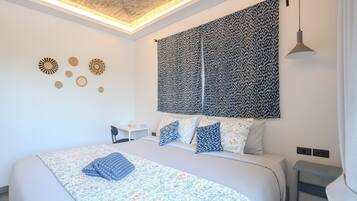 Un dormitorio moderno con una cama grande, un escritorio y un tapiz colgado en la pared.