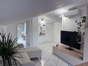 A modern living room with a flat-screen TV, a sofa, a coffee table, and a potted plant. - Cozy attic with a panoramic view from the skylight. (Sirolo)