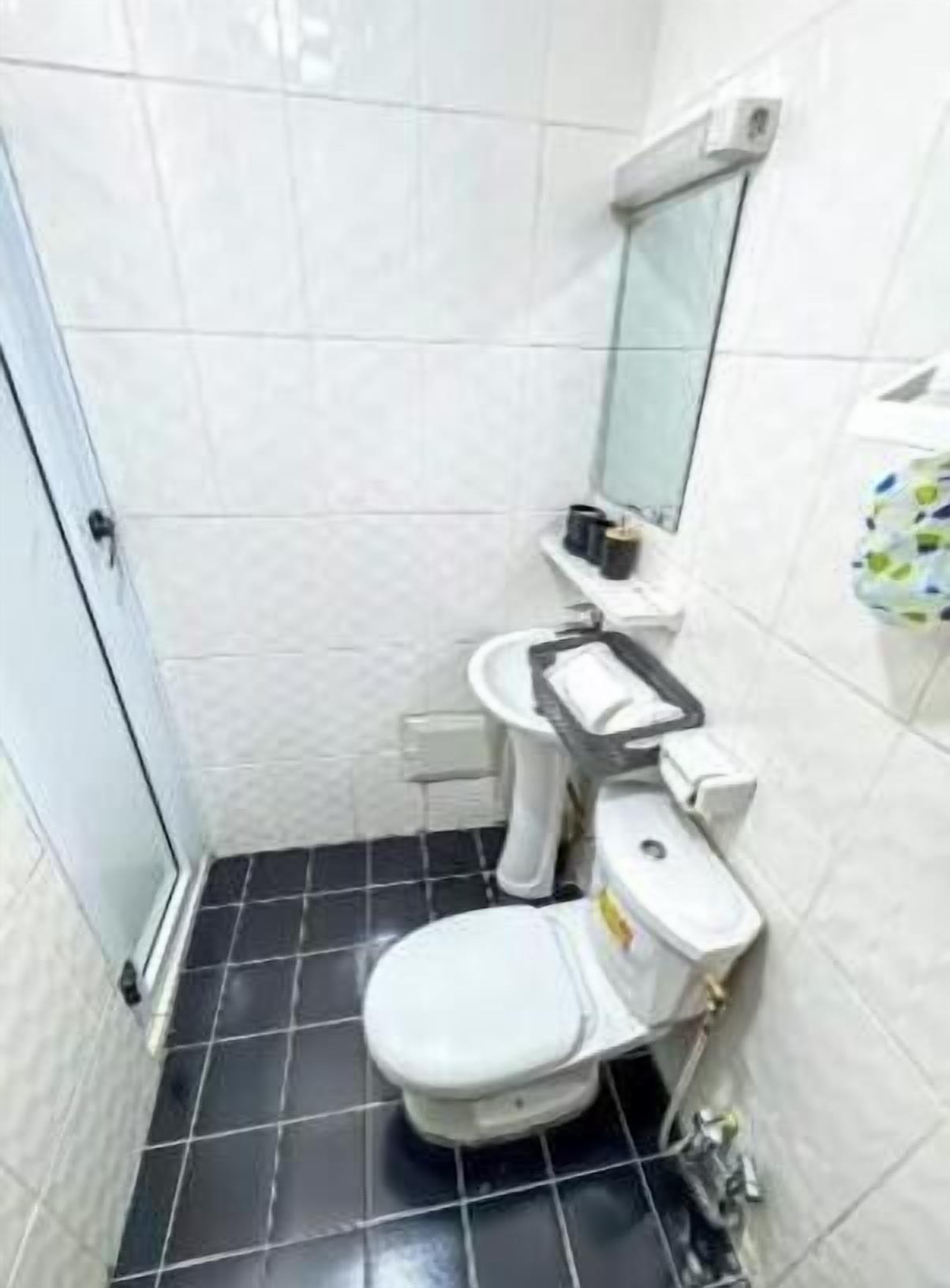 Une petite salle de bain avec des toilettes, un lavabo et un miroir.
