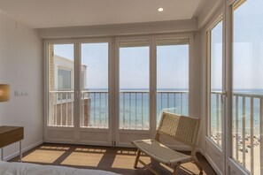 A balcony with a view of the sea, a wicker chair, and a bed with white bedding. - Your beachfront home in Calpe: the perfect retreat for every season.Imagine waking up every morning to the golden Mediterranean light flooding your home, gazing at the breathtaking silhouette of the Peñón de Ifach while enjoying a peaceful coffee on yo (Calp)