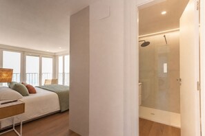 A bedroom with a bed, bedside table, and a view of the sea through large windows. - Your beachfront home in Calpe: the perfect retreat for every season.Imagine waking up every morning to the golden Mediterranean light flooding your home, gazing at the breathtaking silhouette of the Peñón de Ifach while enjoying a peaceful coffee on yo (Calp)