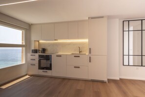 Eine moderne Küche mit integrierten Geräten, einem großen Fenster und minimalistischem Design.