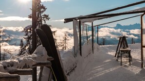 Um teleférico de esqui com paisagem coberta de neve e vista para a montanha ao fundo.