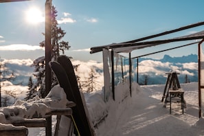 A ski lift with snow-covered surroundings and a mountain view in the background.