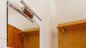 A bathroom with a white sink, a mirror, and a wooden shower enclosure.
