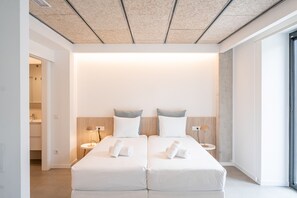 Et moderne hotelværelse med en stor seng, to sengeborde og udsigt ud