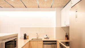 A modern kitchen with a dishwasher, oven, and a coffee machine. - Majordoms Llimoner 1 - Figueres (Figueres)