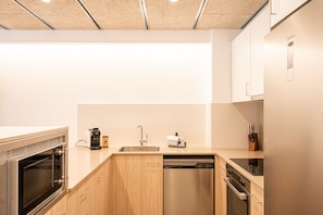 A modern kitchen with a dishwasher, oven, and a coffee machine.