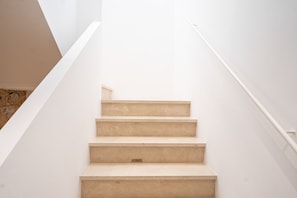 A staircase with a handrail, leading upwards.