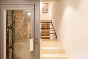 Una escala amb barana i una porta amb un panell de vidre.