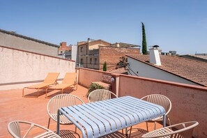 A rooftop terrace with a table and chairs, a view of the cityscape, and a clear sky. - Majordoms Ponent, Banyoles (Banyoles)