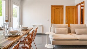 Ein modernes Interieur mit Essbereich, Sofa und zwei Holztüren.