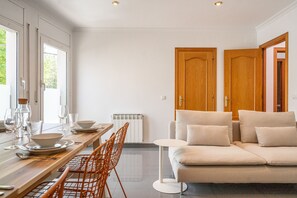 A modern interior with a dining area, sofa, and two wooden doors. - Majordoms Ponent, Banyoles (Banyoles)
