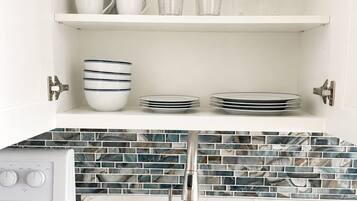 Una cocina con estufa integrada, un lavamanos y salpicadero con azulejos azules y blancos.