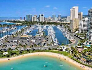 A marina with numerous boats, a beach, and high-rise buildings in the background. - Ilikai Marina - Modern Designer Studio (Honolulu)