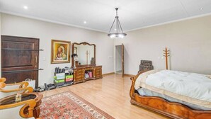Un dormitorio con cama de madera, cómoda, espejo y candelabro.