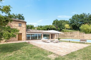 A modern house with a patio, outdoor seating, and a swimming pool. - Antica Dimora delle Tre Coste (Marche)