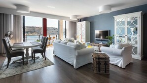 Ein modernes Wohnzimmer mit Essbereich, großen Fenstern und Meerblick.