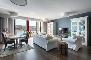 A modern living room with a dining area, large windows, and a view of the sea. - St Angelo Mansions 3BDR flat with Seaview (Birgu)