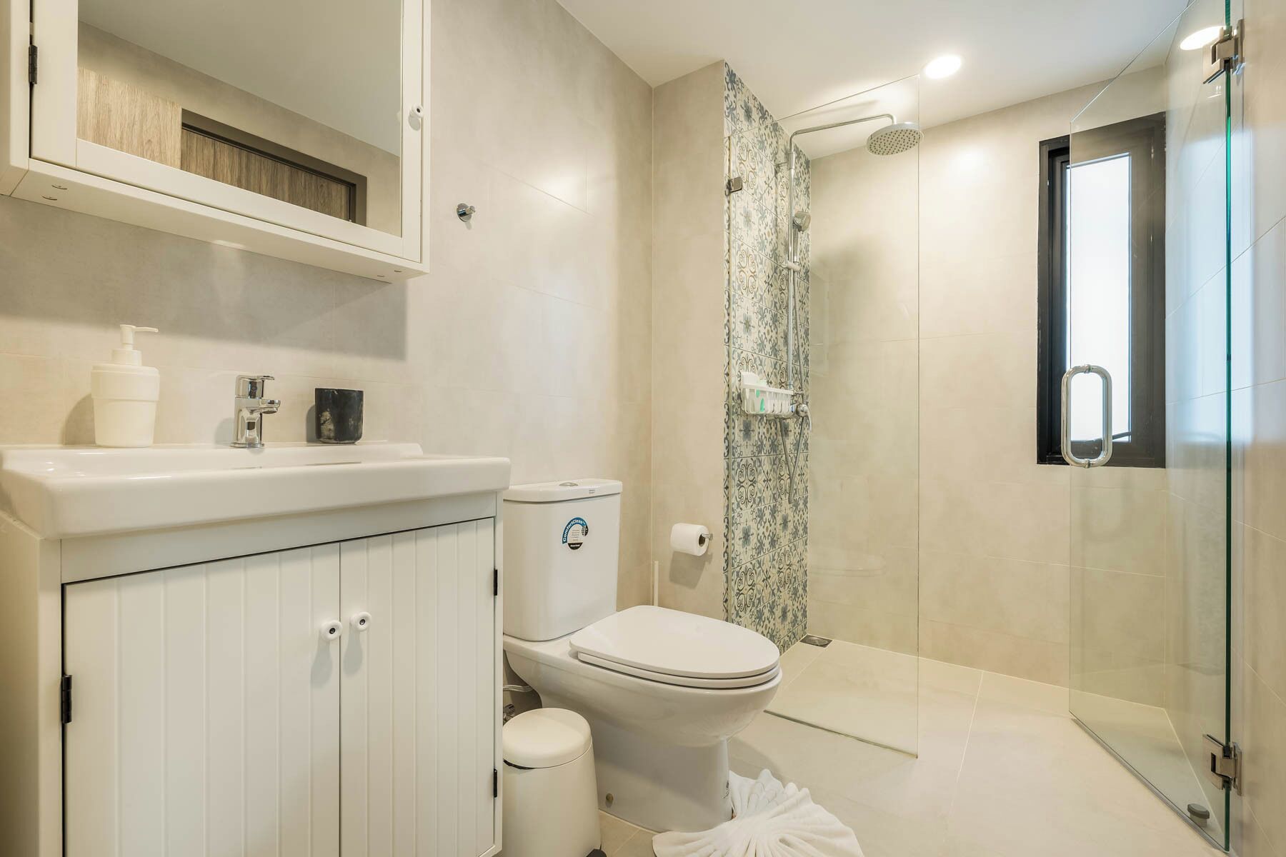 Un bagno moderno con toilette, lavandino e doccia.