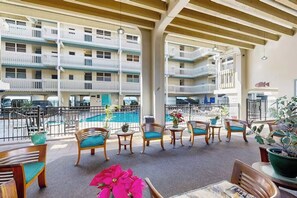 A hotel balcony with multiple levels, outdoor seating, and a pool in the background. - Beautiful Completely Renovated 2 Bed/2 Bath Oceanfront Gem - Kona Bali Kai #313 (Kailua-Kona)