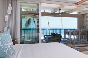 A hotel room with a balcony, a bed, a table, and chairs. - Beautiful Completely Renovated 2 Bed/2 Bath Oceanfront Gem - Kona Bali Kai #313 (Kailua-Kona)
