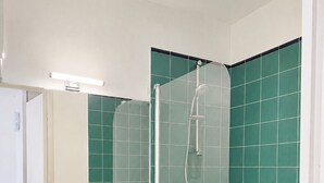 A bathroom with a white sink, black cabinet, and a glass-enclosed shower. - Le Thiers Azur AP4520 by Riviera Holiday Homes (Nice)