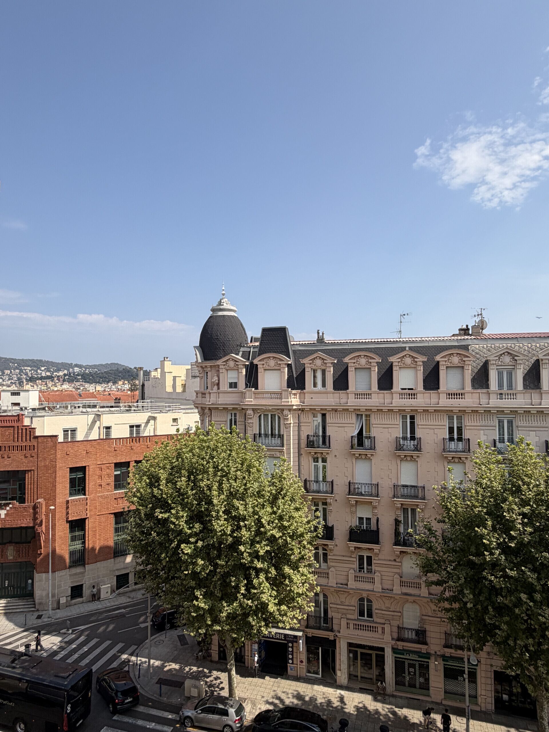 Un immeuble à plusieurs étages, doté d’un dôme imposant et d’une rangée de balcons.