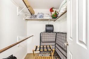 A laundry area with a washing machine, drying racks, and shelves with folded clothes. - Villa 3102 - Chillin' on Lake Time (Lago Vista)
