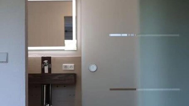 A doorway leading to a room with a window, a door with a handle, and a small rug on the floor. - Rebstock Apartment at the Lahmer August Winery (Kretzschau)