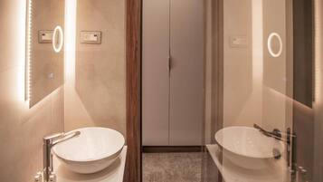 Un baño moderno con dos lavamanos grandes, un espejo y una puerta con pomo.