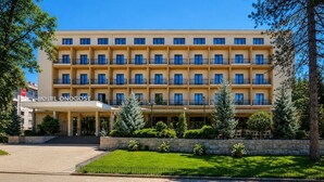 A multi-story hotel with a uniform facade, balconies, and a well-maintained lawn. - Hotel Onogošt (Nikšić)