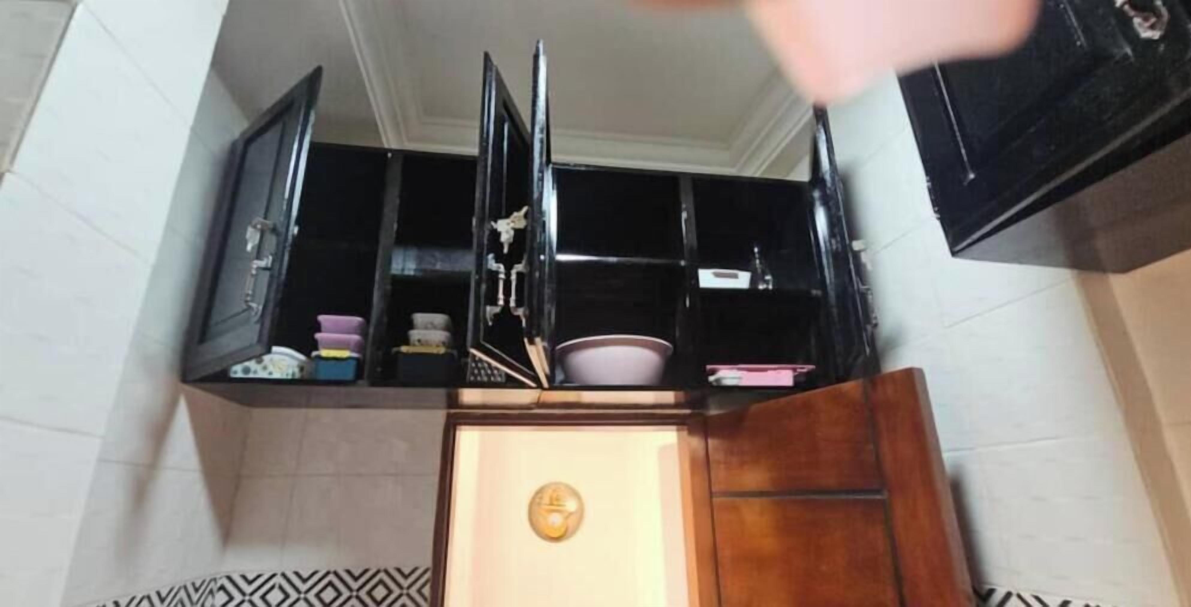 A kitchen with a black cabinet, a white door, and a patterned floor.