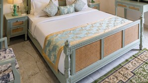 Een slaapkamer met een bed, twee nachtkastjes, een plafondventilator, een spiegel en een nachtkastje.