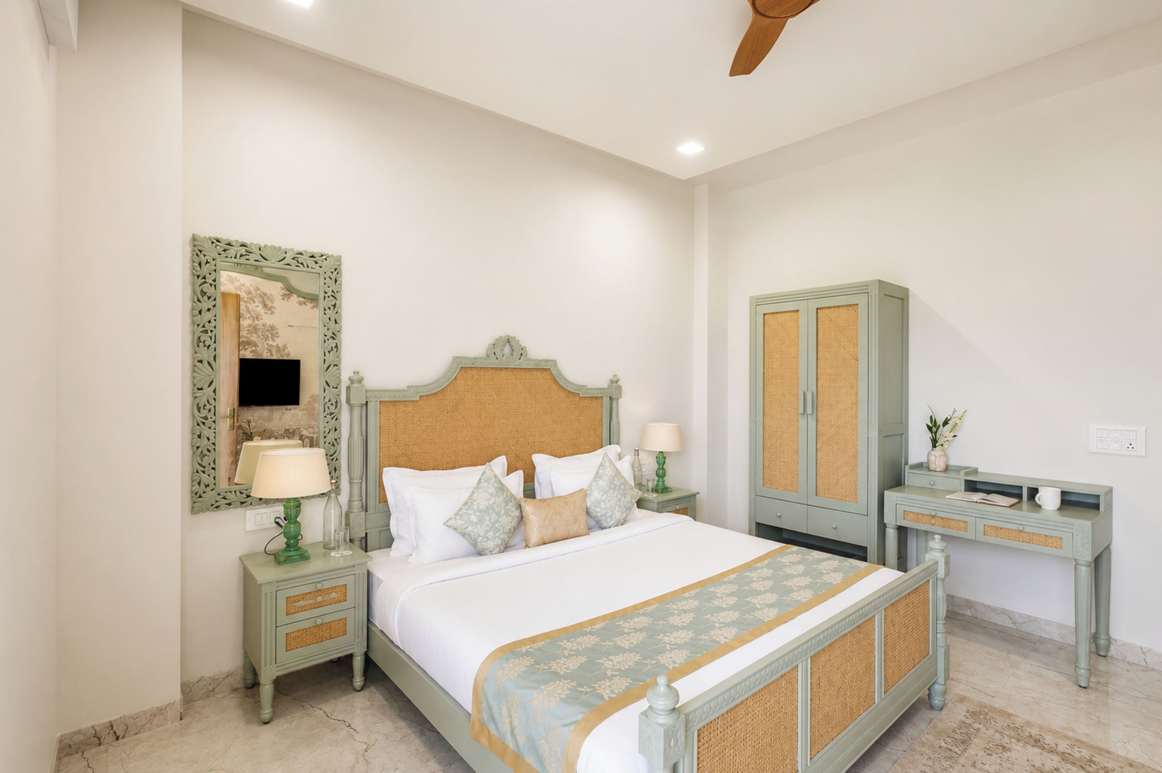 A bedroom with a bed, nightstands, a dresser, and a mirror.