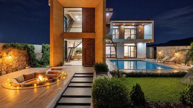 Een modern huis met twee verdiepingen, een zwembad, terras en een trap naar de bovenverdieping.