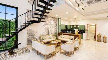 Um interior moderno com escada, área de estar, cozinha e vista para o verde.