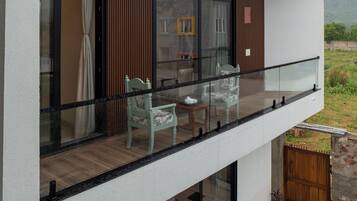En moderne toetages bygning med balkon, store vinduer og udsigt til naturen.