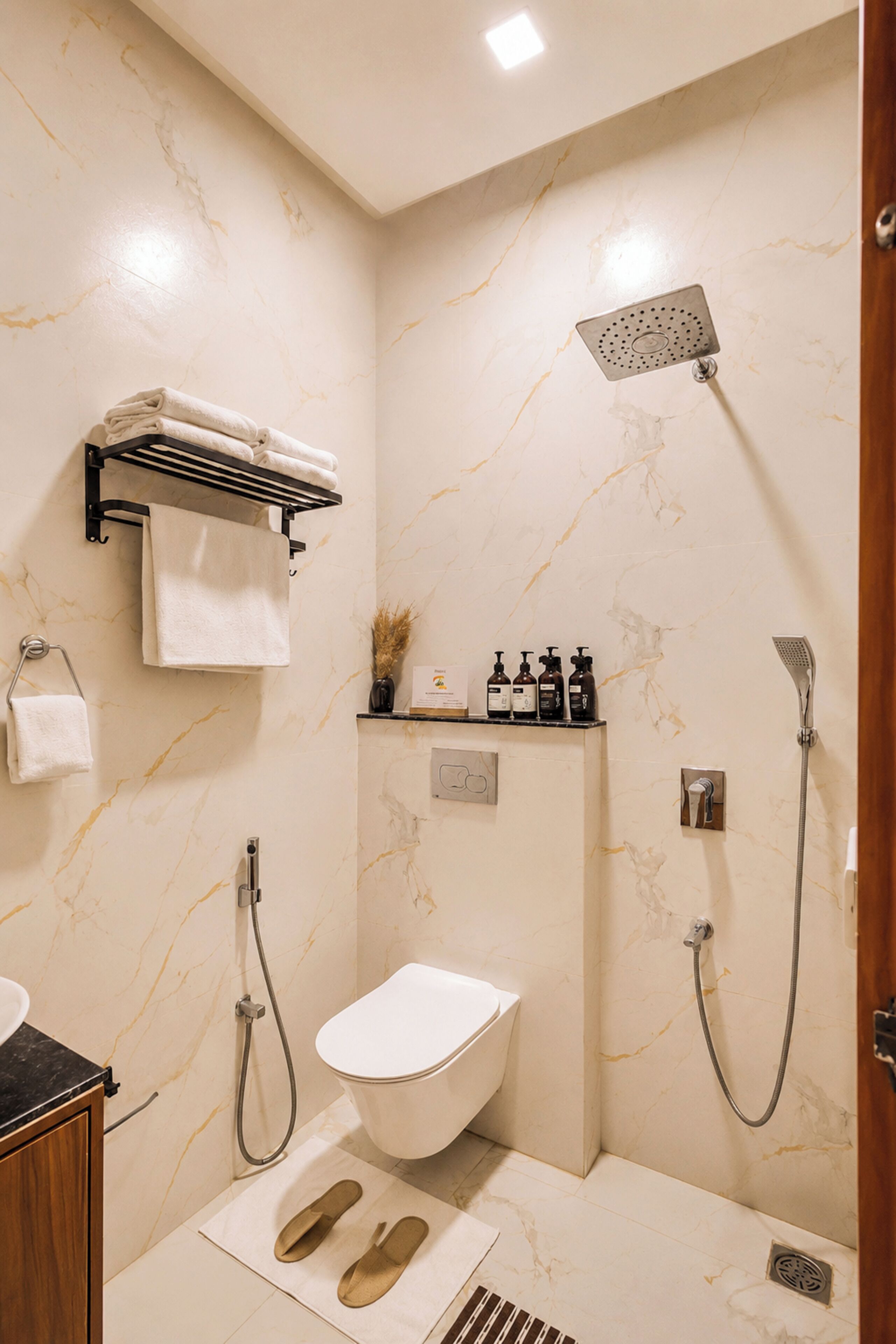 Een moderne badkamer met een douche, toilet en een handdoekhouder.
