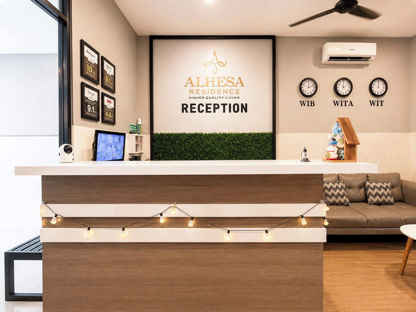 Un área de recepción con mostrador, aire acondicionado de pared y un reloj que marca la hora.