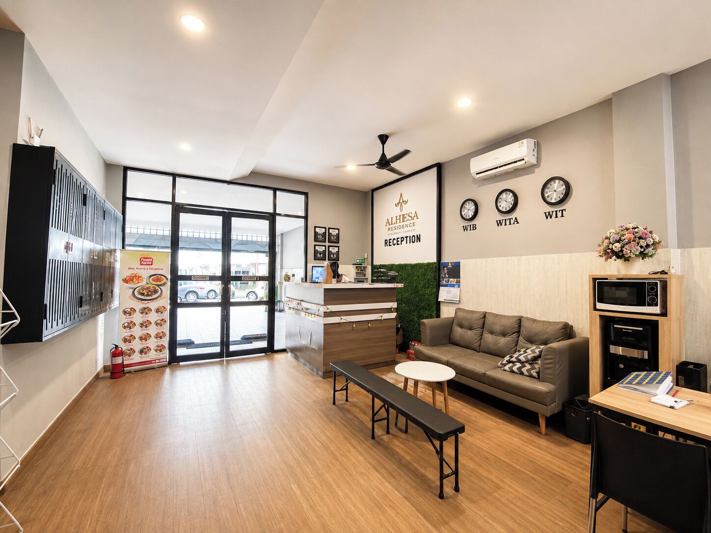 A reception area with a reception desk, a sofa, a bench, a clock, and an air conditioning unit.