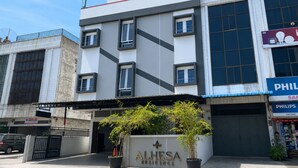 Un edificio moderno con un cartel que dice 'ALHESA RESIDENCE' y un escaparate visible con la marca 'PHILIPS'.